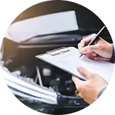 Механик делает записи в блокноте при осмотре автомобиля.