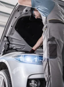 Фотография автомеханика с автомобилем.