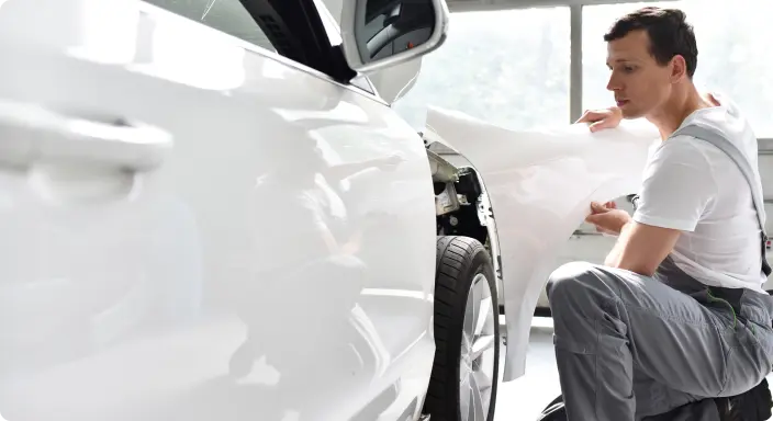 Мужчина чинит автомобиль.